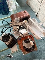 Group shot showing camera, radios, cords, adapters on glass table