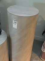 Tall cylindrical pedestal full height with partial view of second pedestal