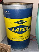 Front view of blue and yellow Dow Latex steel drum with lid