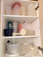 Cabinet view showing all shelves with assorted containers and drinkware
