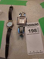 Both wristwatches laid flat showing overall condition and size comparison