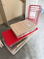 Stacked view of three totes with lids and red wire rack