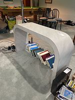 Full view of gray concrete-look console table with books for scale