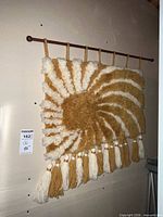 Cream and mustard spiral macrame wall hanging on dowel with tassel fringe