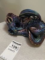 Overall view of iridescent sleeping dragon figurine on tabletop