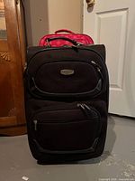 Front of large black Dockers suitcase with pink suitcase partially visible