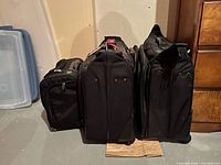 Front view of three black suitcases side by side