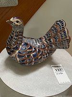 Full view of hand-painted ceramic bird figurine showing color and form