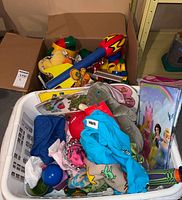 Laundry basket of plush, blocks, princess cape and accessories