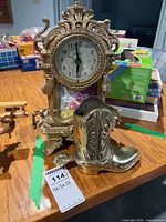Mantel clock and brass boot on table