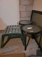 Two metal frame glass top patio tables and resin foot stool