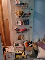Door rack and floor boxes filled with paperback books and magazines