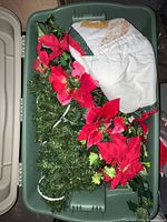 Tote containing poinsettia garland, tree skirt and banners