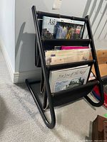 Full view of black metal magazine rack filled with magazines