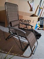 Full view of zero gravity recliner chair showing frame, fabric, pillow
