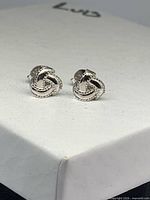Front view of both sterling silver knot studs on box lid
