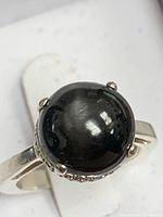 Top view showing black star sapphire cabochon and prong setting