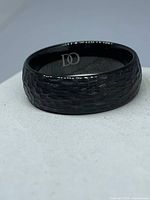 Ring angled view showing hammered texture and matte black finish