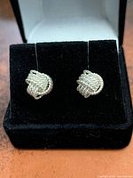 Front view of sterling silver rope knot stud earrings in display box