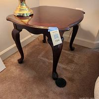 Full view of one end table showing shape, legs, and finish