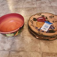 Stacked serving bowl and dinner plates showing motifs and general condition