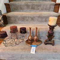 overview of all candle holders, candles, and wooden vases on staircase