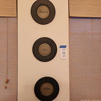 Vertical arrangement of three round plaques on wall