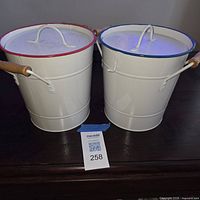Front view of both enamel buckets with lids