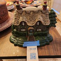 Front view of cast iron cottage doorstop showing overall design and paint