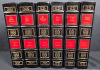 Spine view of all six volumes showing titles, red labels, gilt decoration