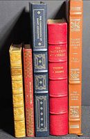 Spine view of all five books showing titles, gilt tooling, varying colors