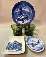 Group shot of three Royal Copenhagen plates and two Dansk green glass candleholders