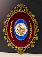 Full view of ornate brass frame, velvet, porcelain plaque