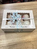 Top view of sealed box showing five bath bombs and ribbon