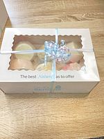 Front view of boxed bath bombs with ribbon, window shows contents