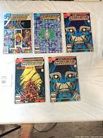 Five bagged and boarded Crisis on Infinite Earths comics displayed on table