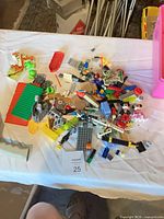 Pile of mixed bricks and parts on table, various colours and elements visible