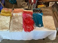 Overview of entire lot of packaged rosette scarves on table