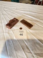 Full lot showing two copper ingots beside coin for scale