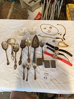 Group shot showing all flatware, jewelry, watches, Zippos, paperweights