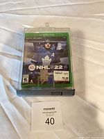 Front view of sealed NHL 22 game in security case showing full artwork and price sticker
