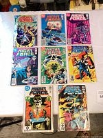 Eight bagged Night Force comics laid out showing all covers