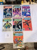 Seven bagged Power Man and Iron Fist comics laid out