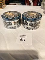 Front view of two factory-wrapped geometric candles