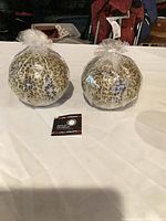 Two wrapped leopard-print round candles with Swazi Candles tag visible