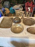 All pieces arranged on table showing variety of trays, bowl, covered dish and candlesticks