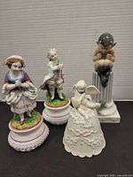 Group view of all four figurines: girl, boy, angel bell, Royal Copenhagen elf