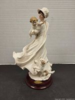 Front view of figurine showing woman, child, dog and base