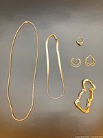 All five gold jewellery pieces laid out