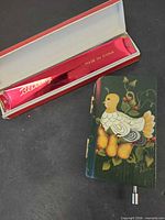 Harmonica in case next to painted wood music box